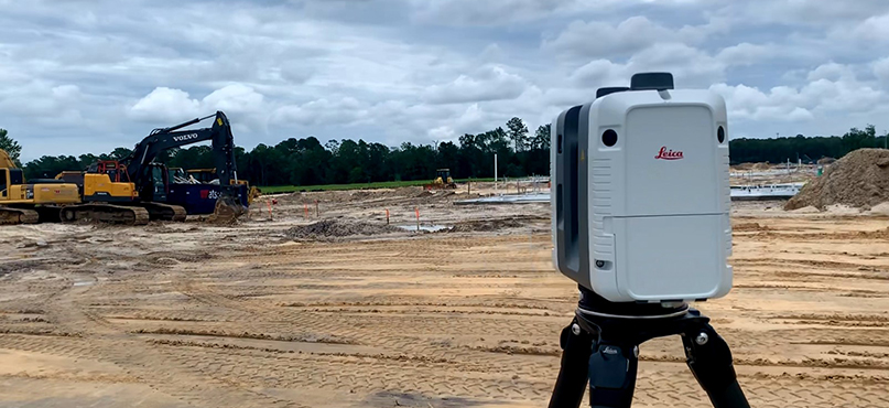 Laser scanner on a construction site with heavy construction machinery 