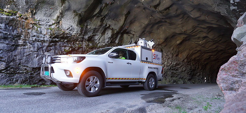 White truck with a mobile mapping unit drives through a tunnel 
