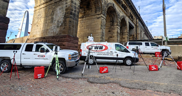 TWM Geospatial Services fleet of vehicles and 3D laser scanning hardware lined up under a bridge